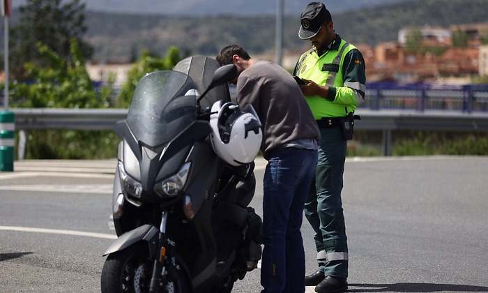 Un agente de la Guardia Civil para a una moto en un control de tráfico