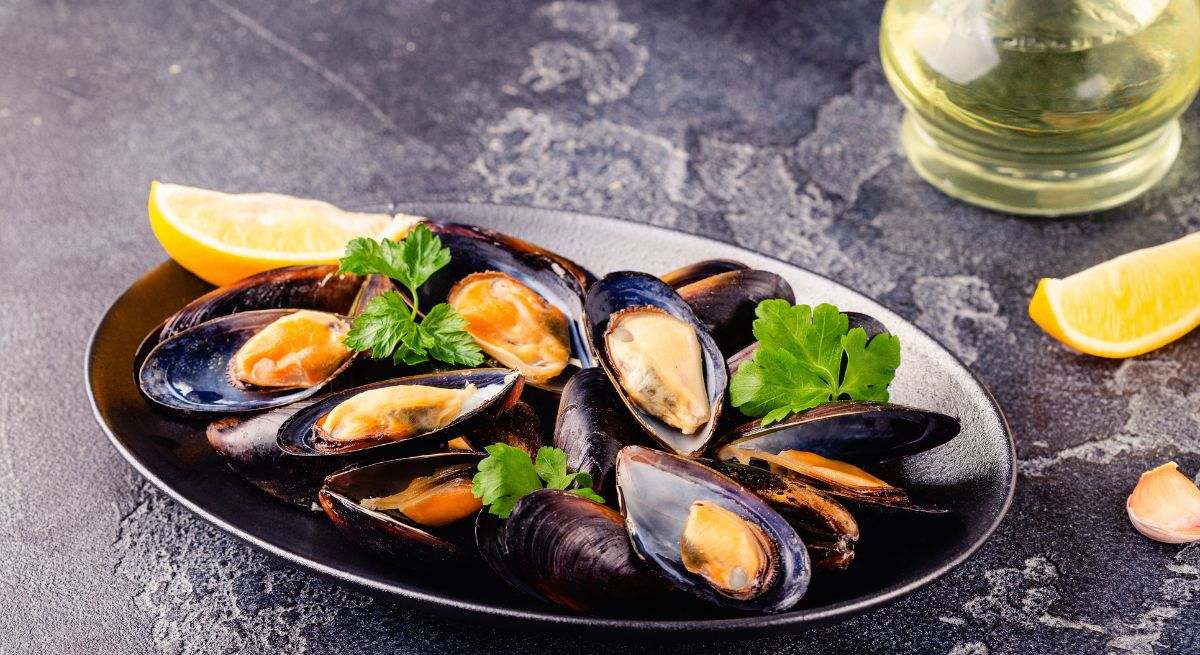 Mejillones al vapor con un poco de perejil y rodajas de limón