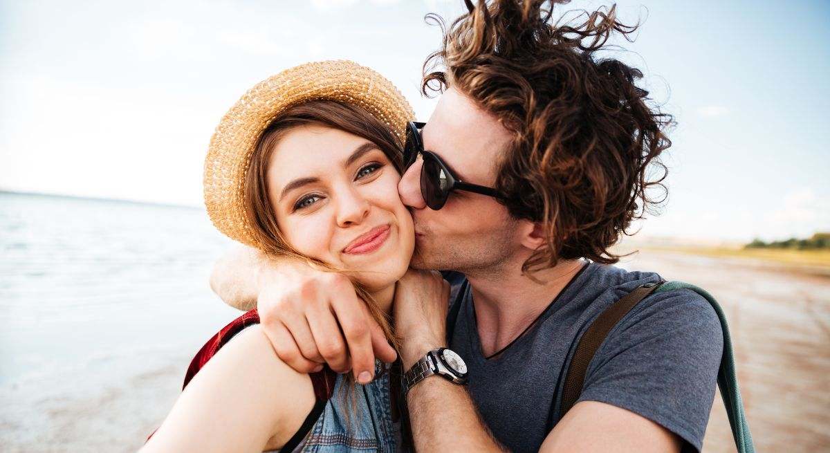 Una pareja enamorada se da un beso en la playa