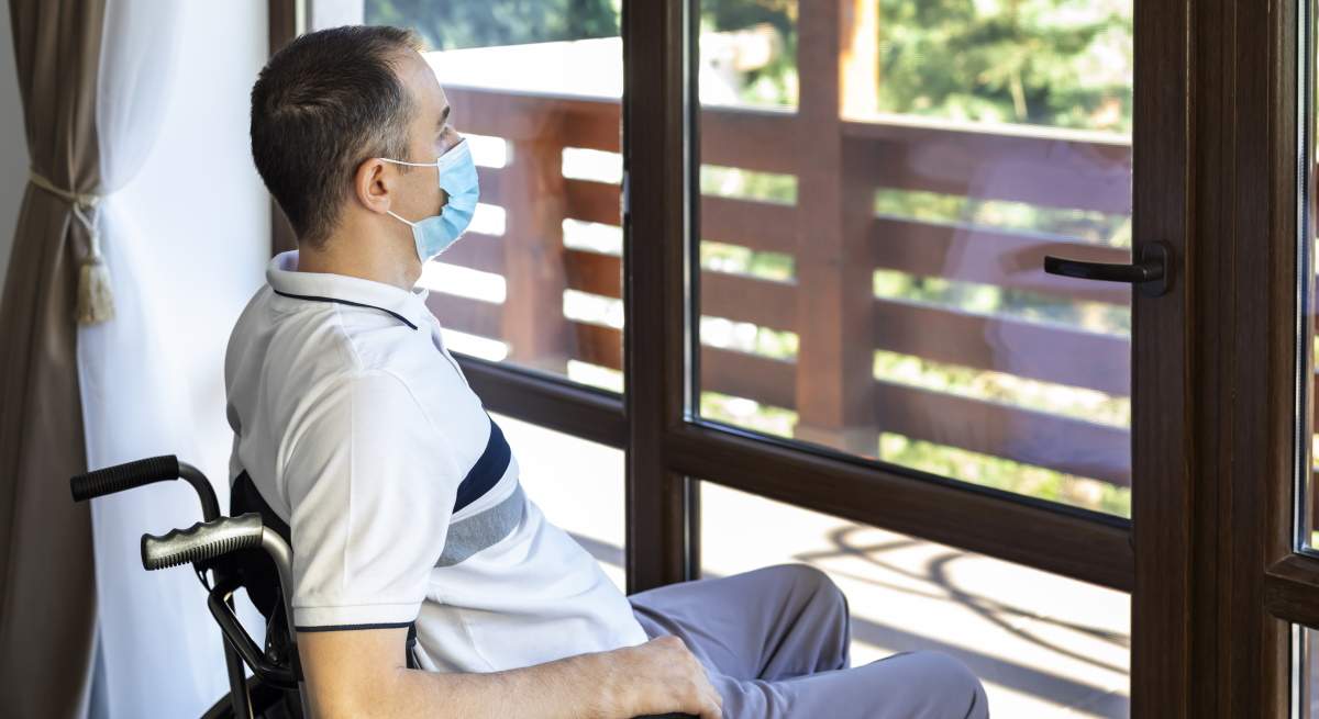 hombre-silla-ruedas-mira-ventana-dreamstime.jpg