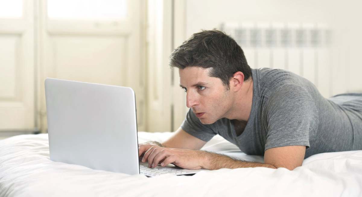 hombre-tramite-ordenador-tumbado-dreamstime.jpg