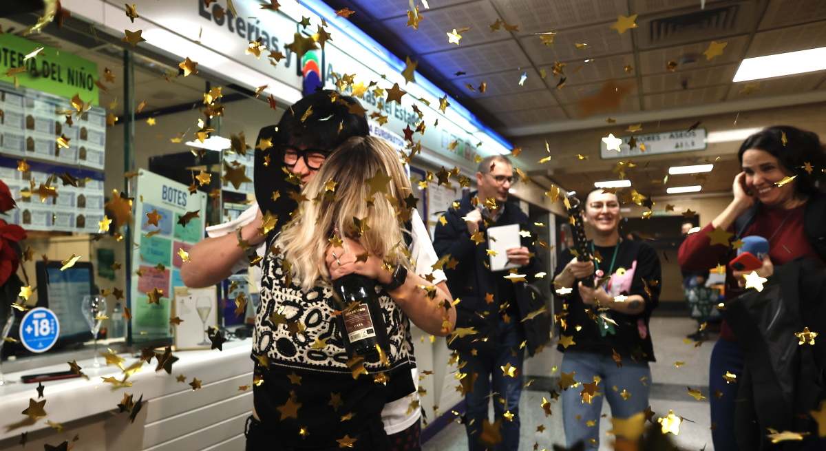 Premiados con el 'Gordo' celebran en una administración de Lotería.