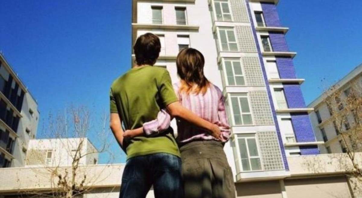 Dos jóvenes ante un bloque de viviendas / EP