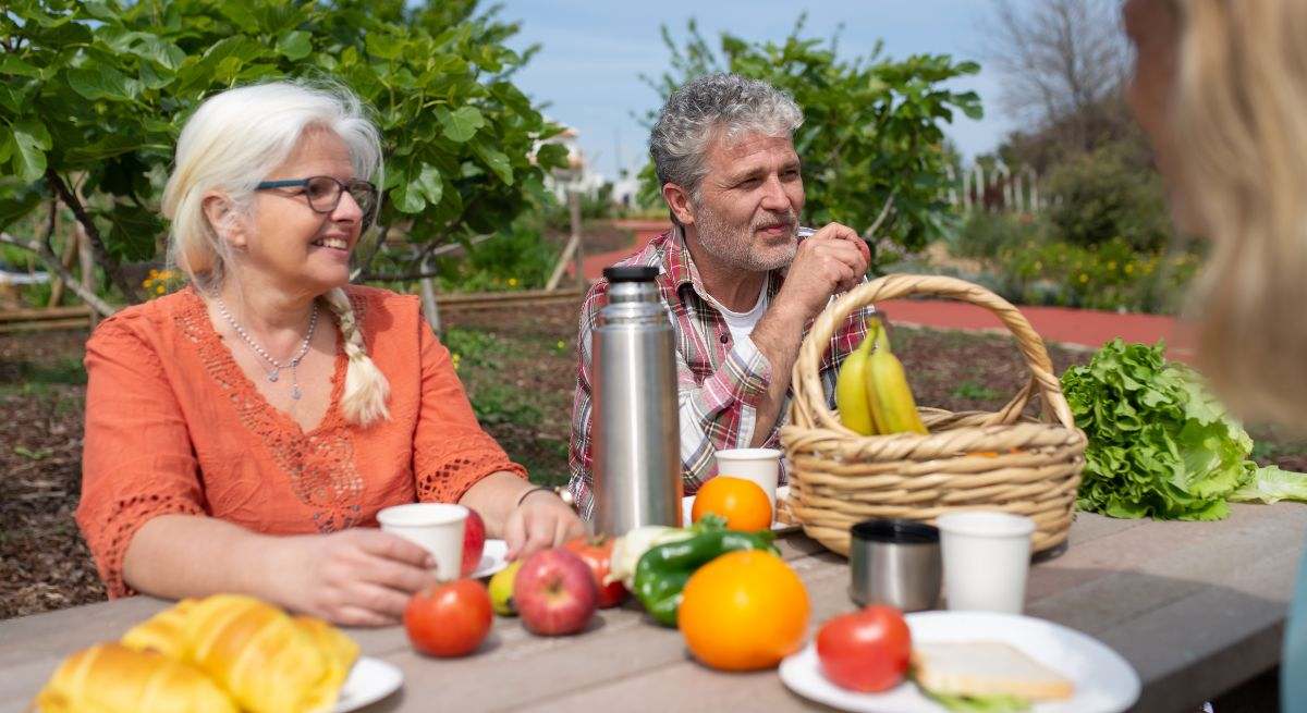 Una pareja de avanzada edad come en su jardín