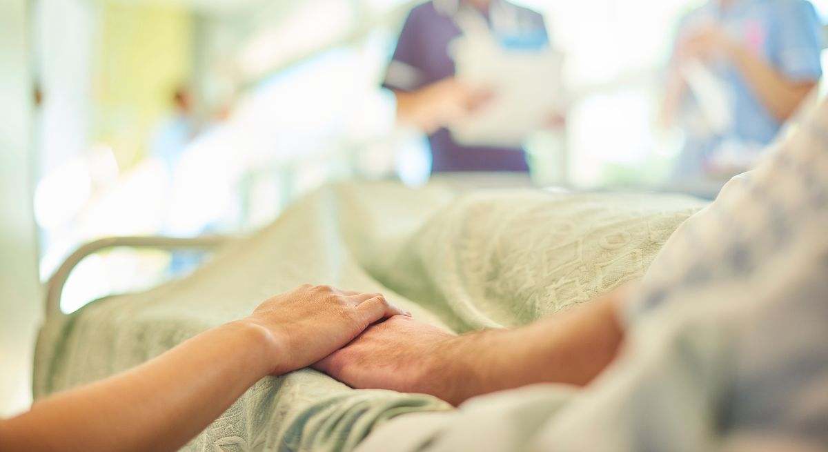 Paciente en el hospital dando la mano a otra persona