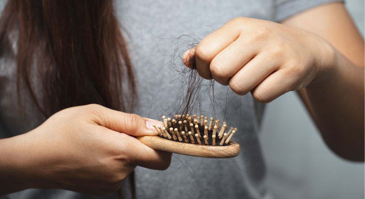 Una mujer muestra la caída de pelo en su peine