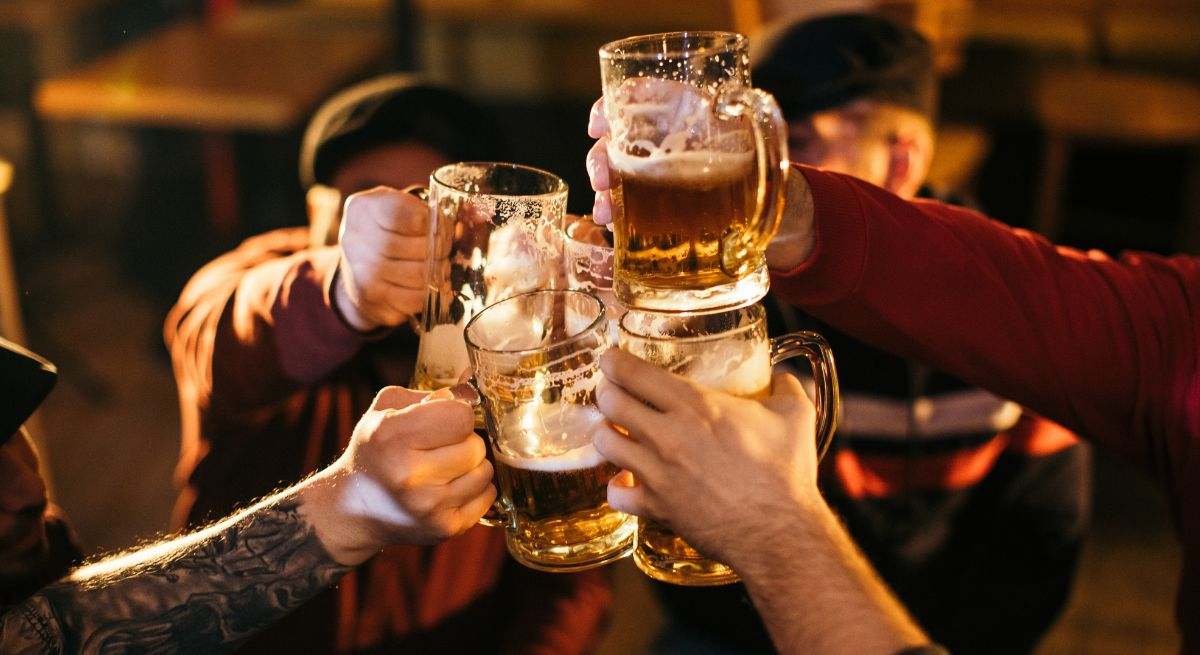 Varias personas brindan con cerveza en un restaurante