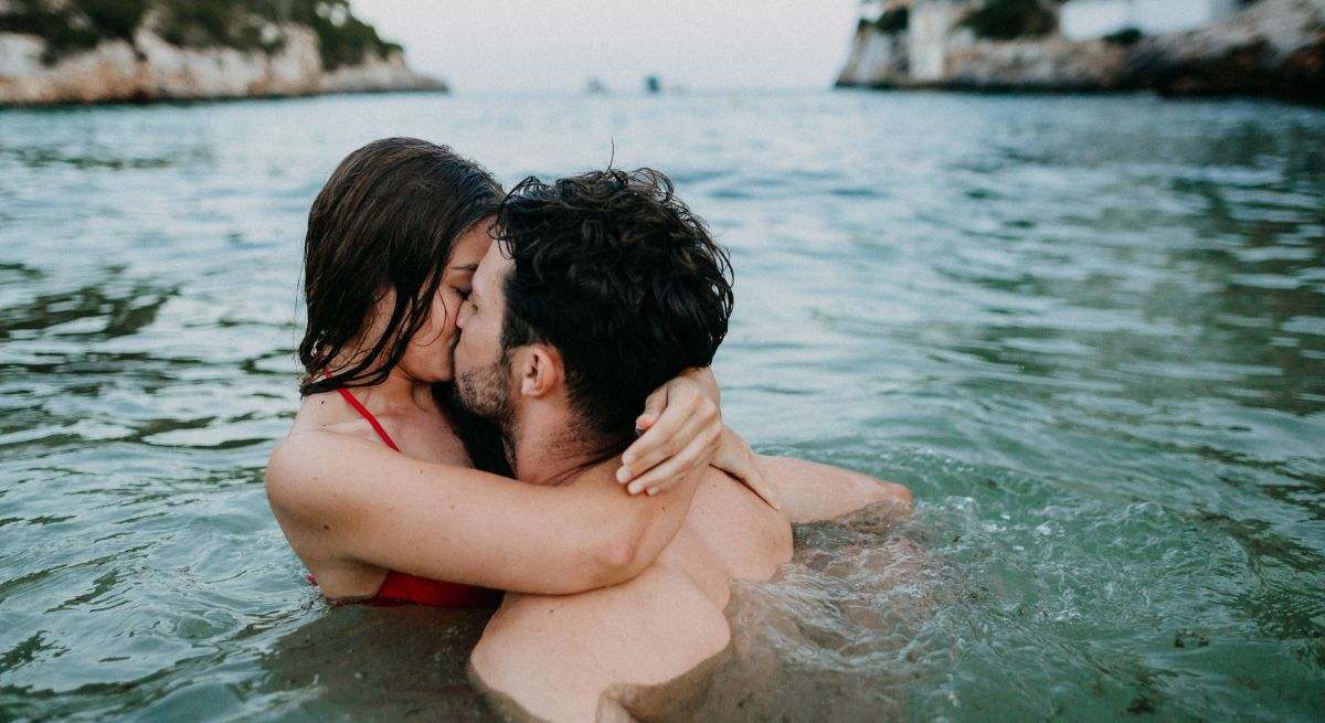 Una pareja se besa en el mar
