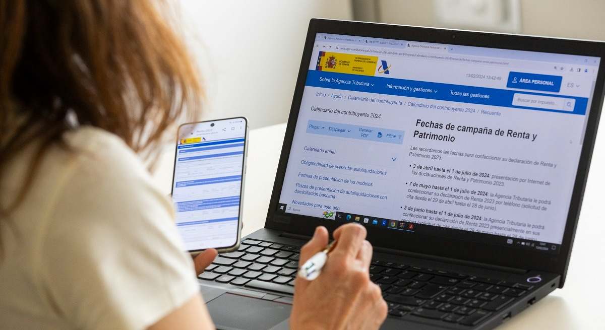 Una mujer mira información sobre la declaración de la Renta