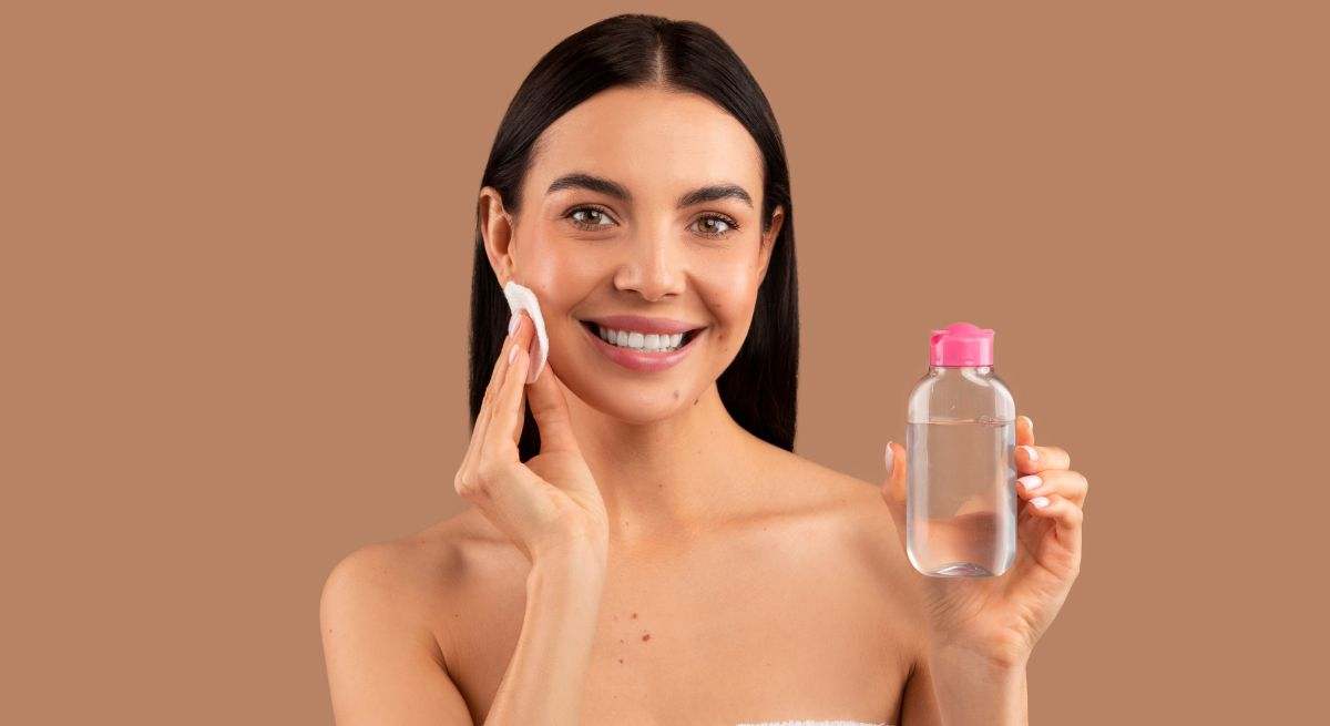 Una mujer sostiene agua micelar en su mano