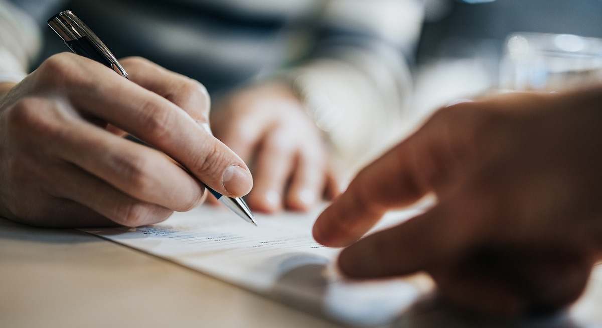 dos personas firman un contrato