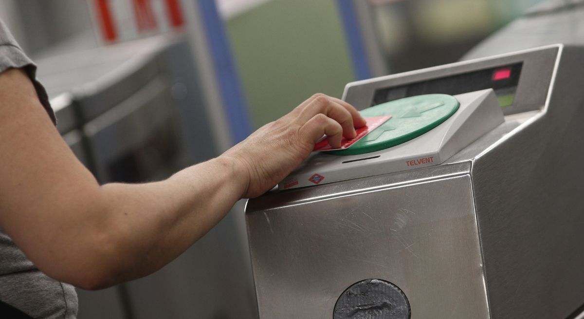 Una mujer pasa el abono de transporte de Madrid por el torno. / Foto: EP