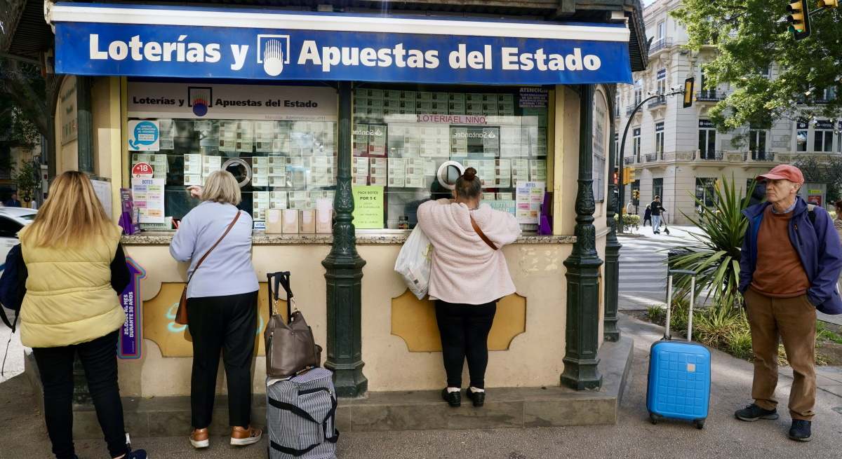 Ciudadanos compran lotería en un kiosko.