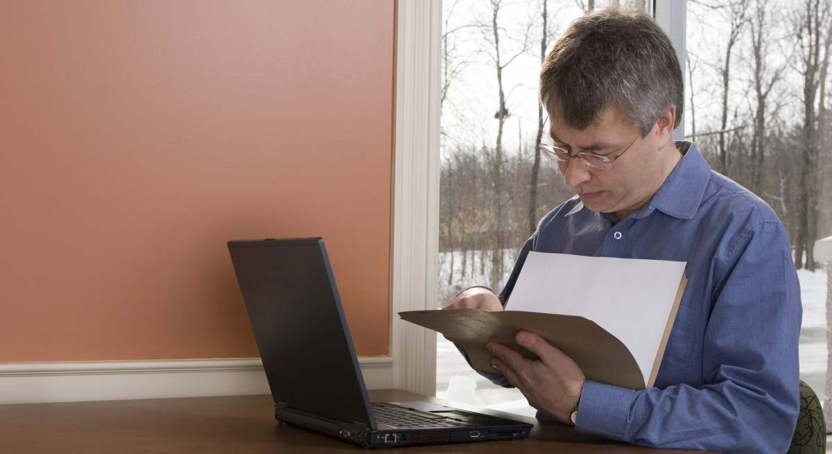 trabajador-consulta-documento-ordenador-dreamstime.jpg