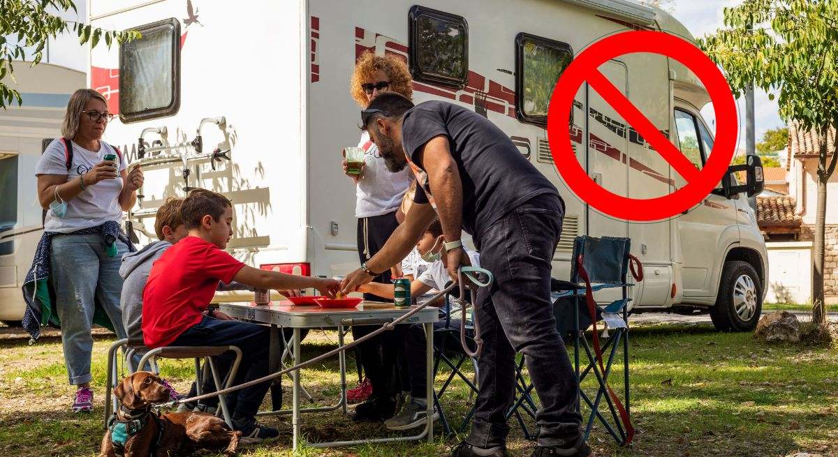 Una familia con niños tomando un refrigerio junto a su autocaravana en un área de servicio