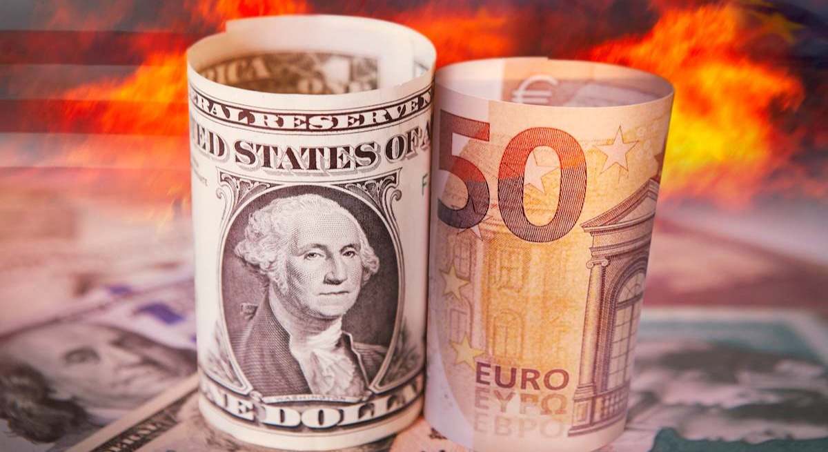 Un billete de 50 dólares y otro de 50 euros ardiendo