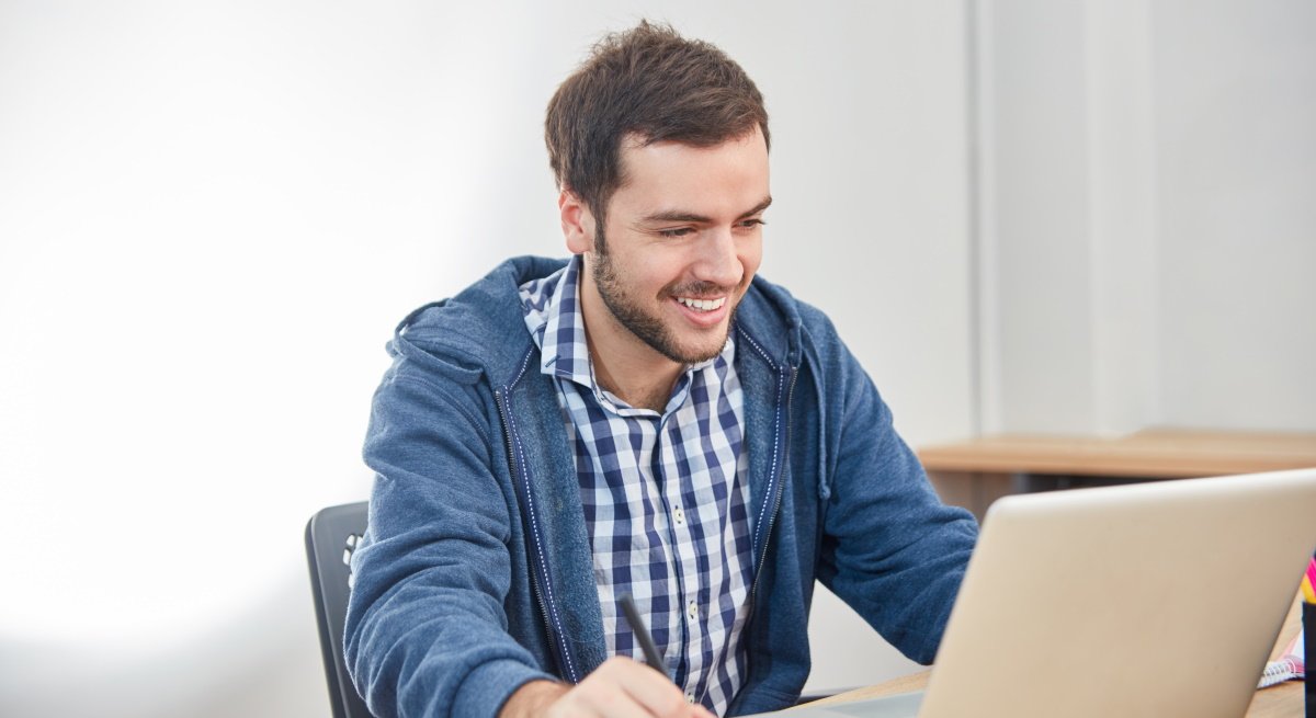 hombre-sonrie-tramite-ordenador-dreamstime.jpg