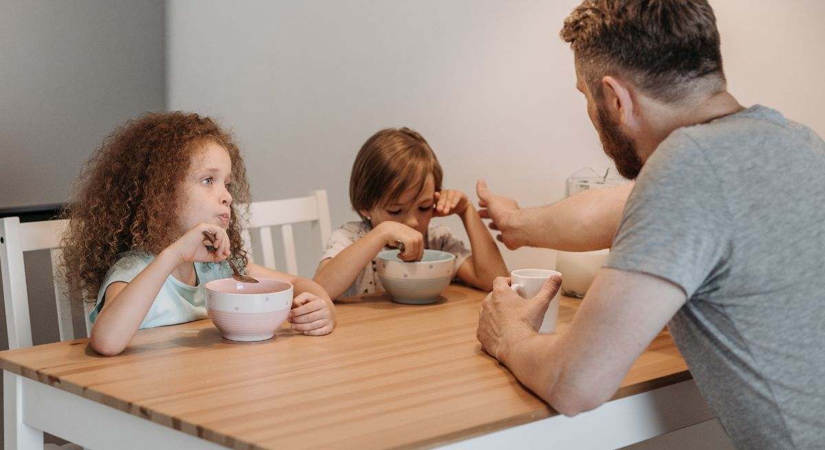 Padre comiendo con sus hijos