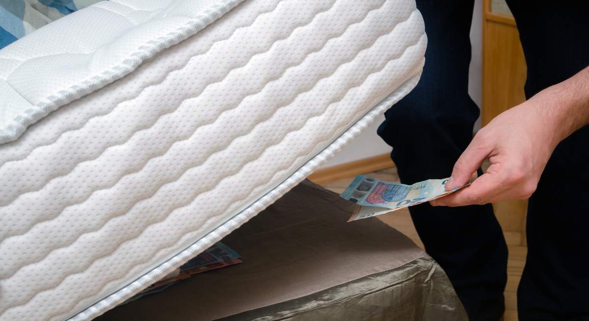 persona-guarda-billetes-bajo-colchon-dreamstime.jpg