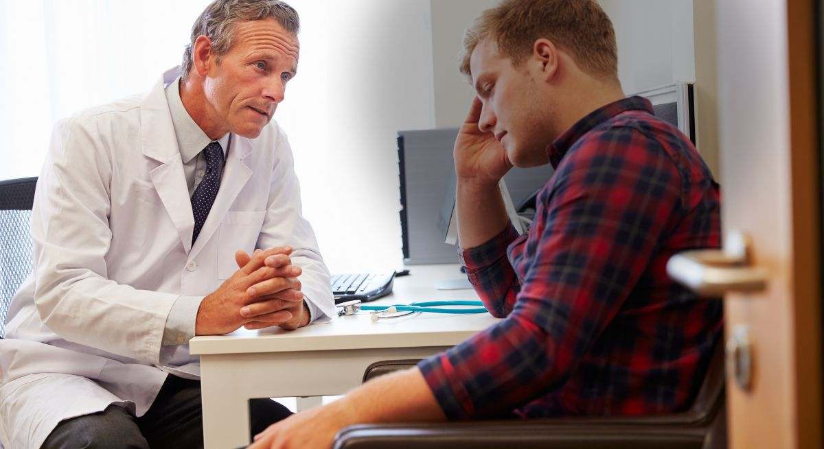 Hombre recibiendo un diagnóstico en la consulta del médico