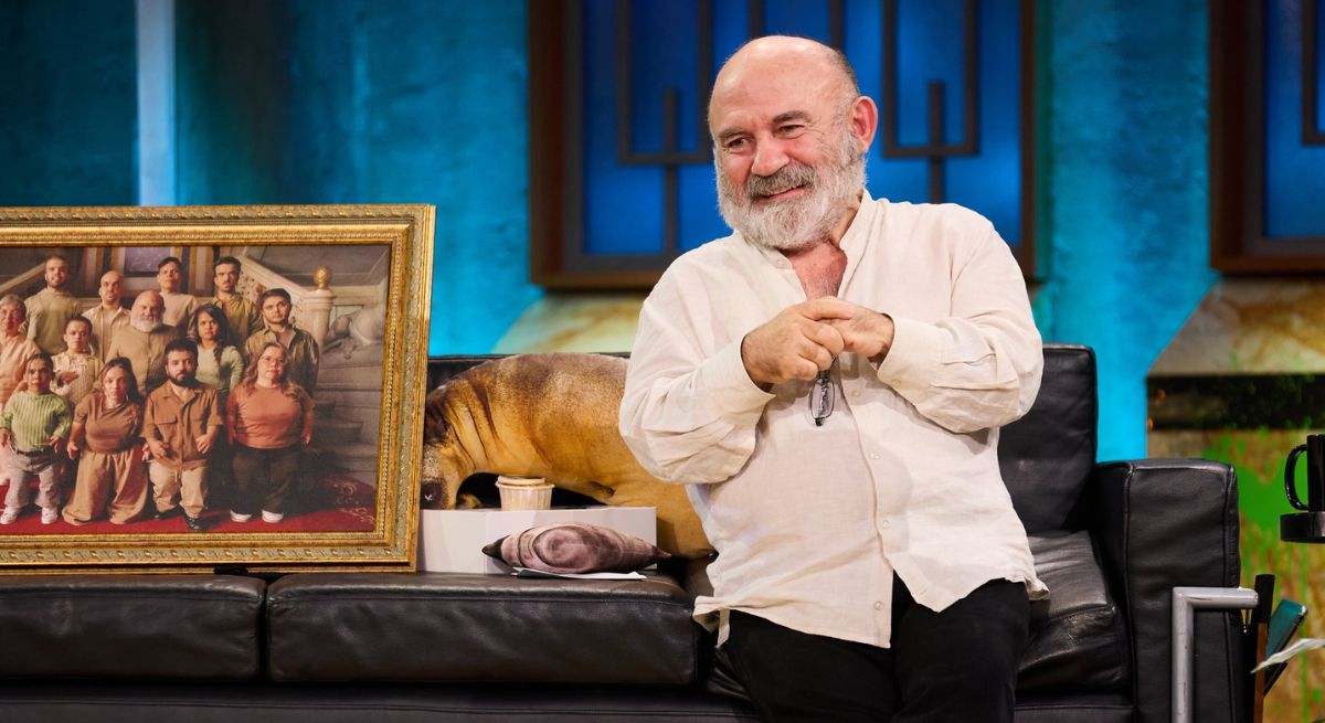 Emilio Gavira sentado en el sofá de Broncano junto a un cuadro con personas de su asociación