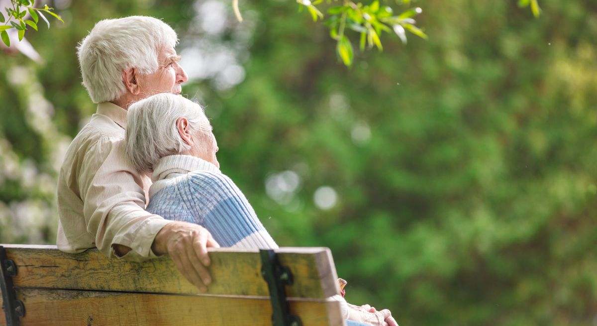 Una pareja de ancianos sentados en un parque
