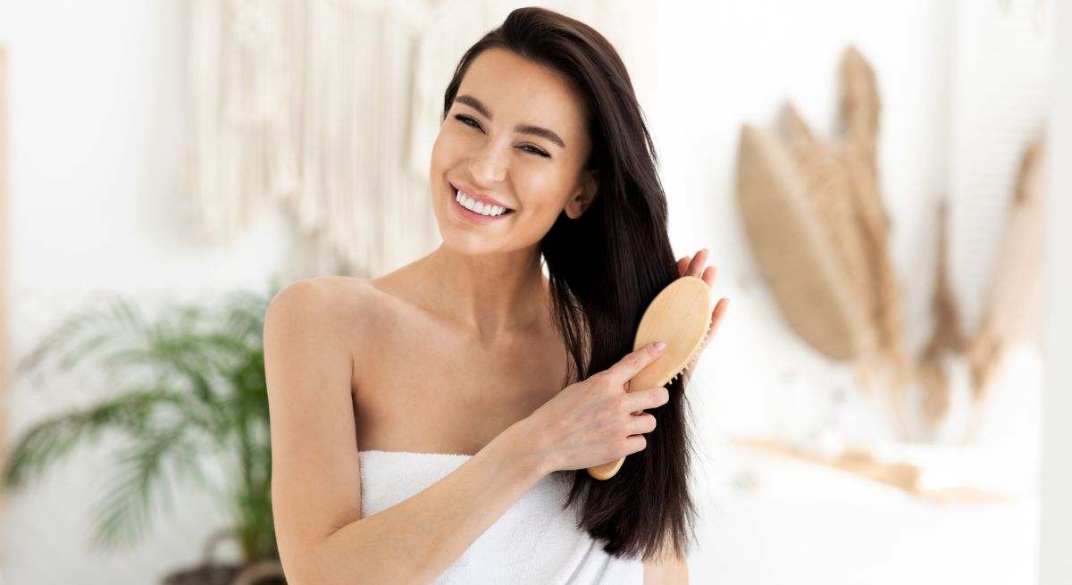 Chica cepillándose el pelo con un cepillo de madera