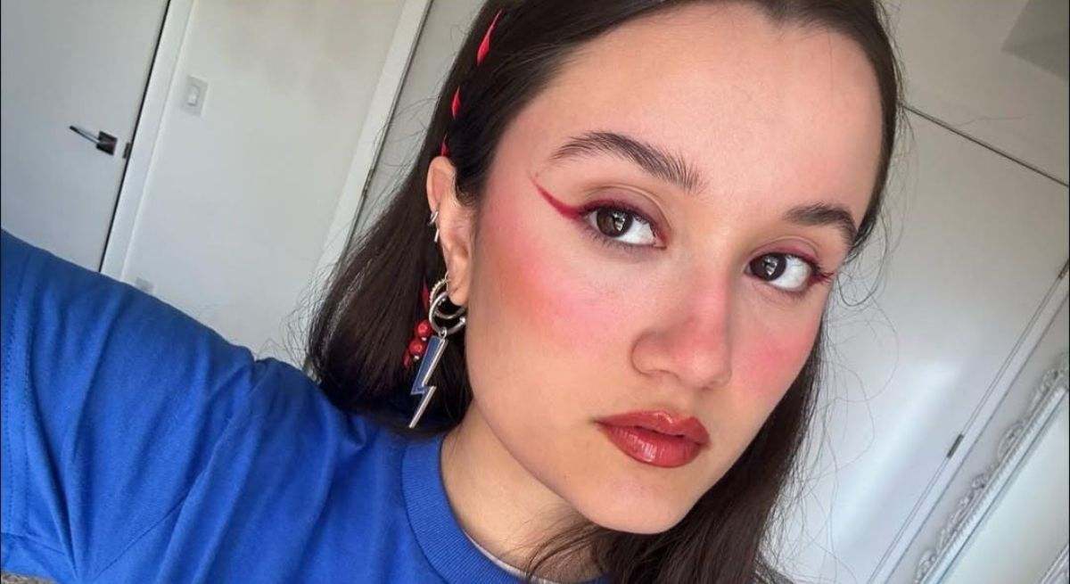 La cantante con camiseta azul y maquillaje posando en un selfie