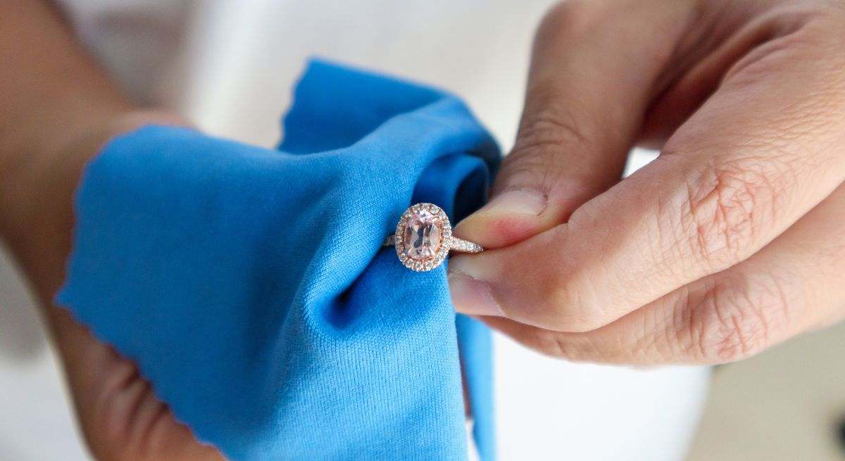 Persona limpiando un anillo con un paño azul