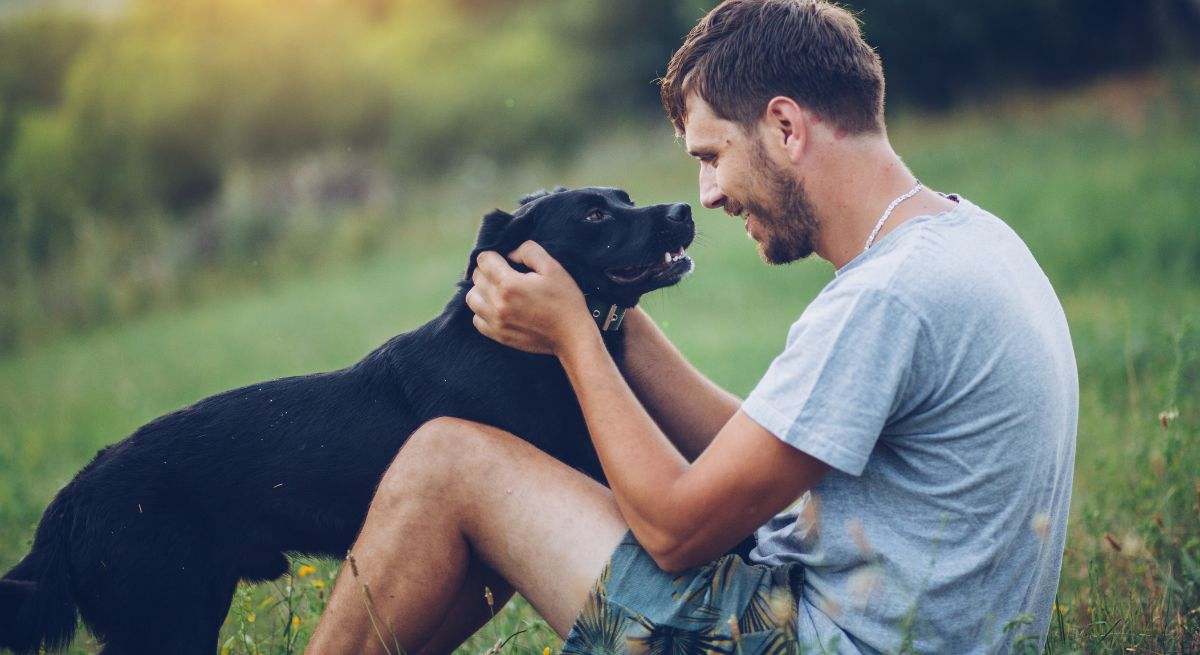 Un hombre con su perro en el césped