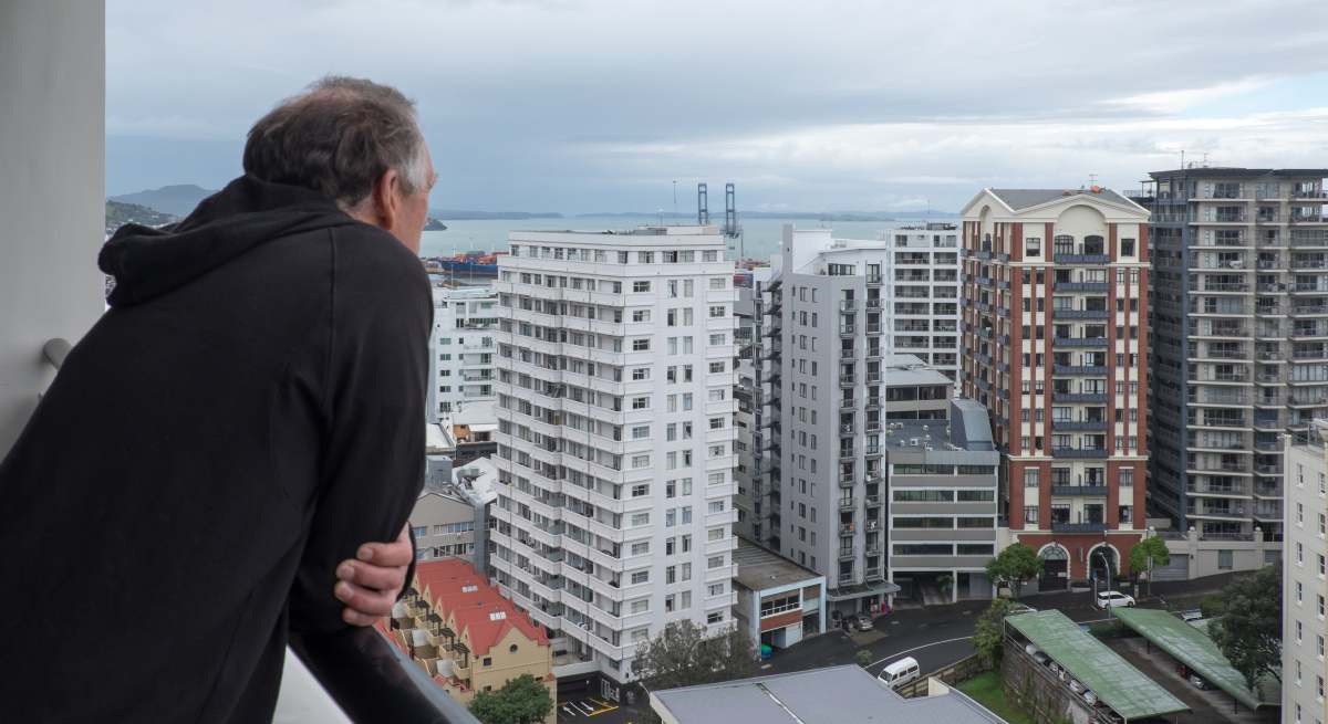 Un jubilado, asomado desde una terraza.