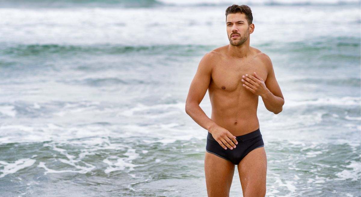 Un hombre, en la playa, con su bañador puesto