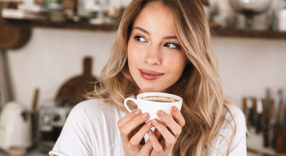 Una persona bebe café antes de ponerse a trabajar con el ordenador