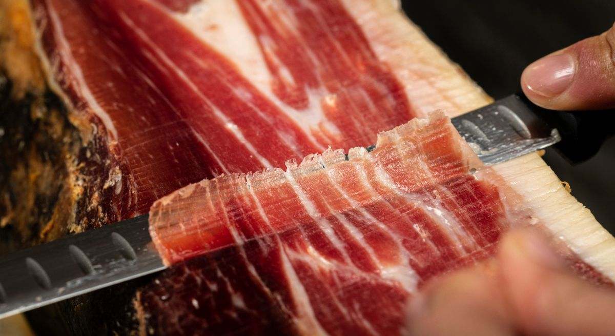 Persona cortando pata de jamón serrano