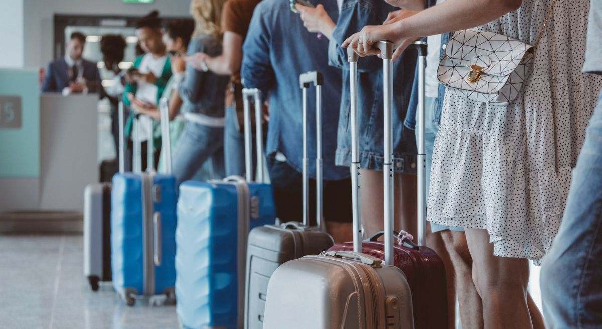 Grupo de personas haciendo cola en un aeropuerto