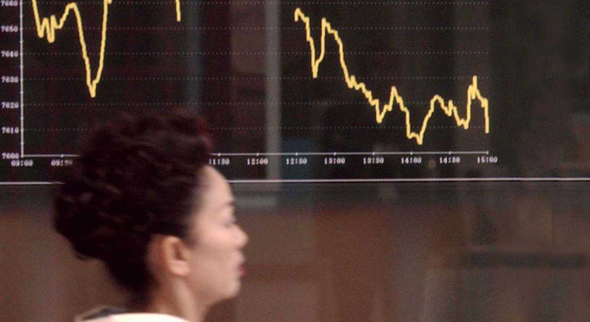 Una mujer japonesa ante un gráfico de la bolsa