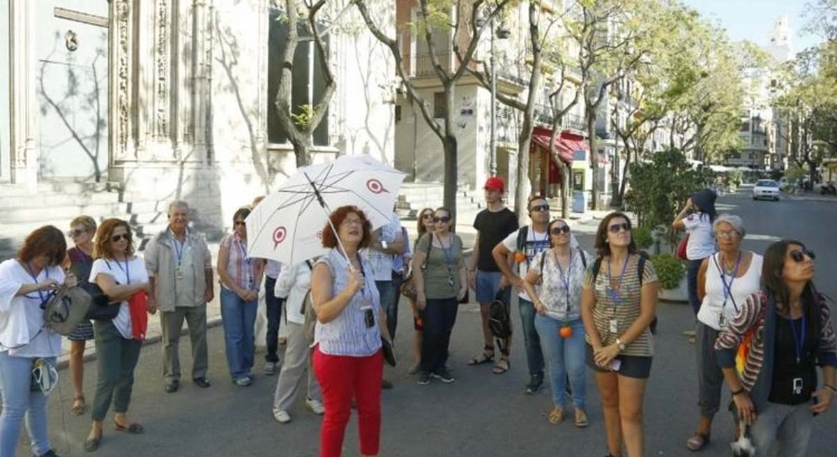 Un grupo de turistas junto a la Lonja de la Sede de Valencia, declarada Patrimonio de la Humanidad.