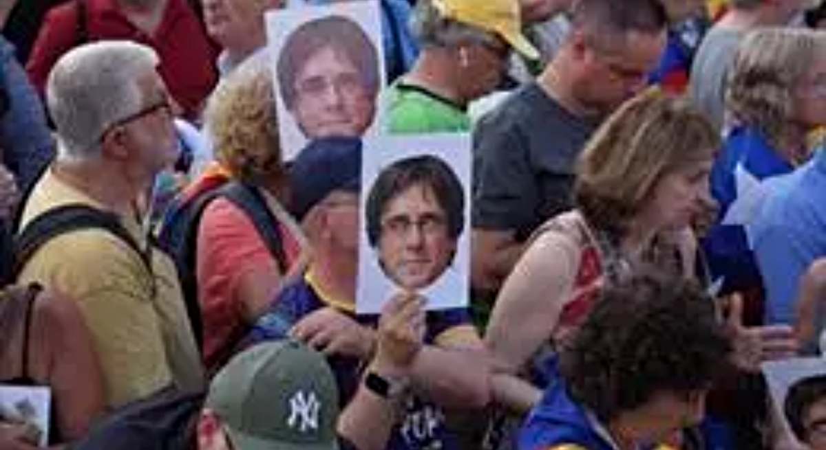 Varias personas con fotos con la cara de Puigdemont / EP