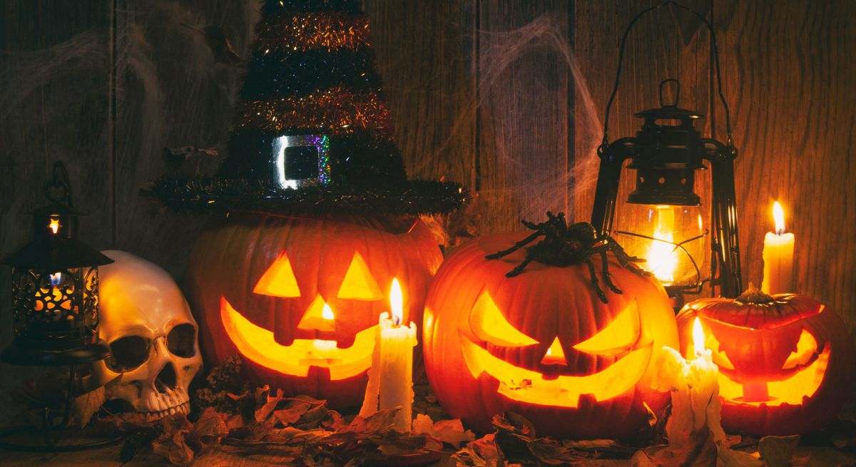 Calabazas de Halloween con gorros de brujas y velas encendidas