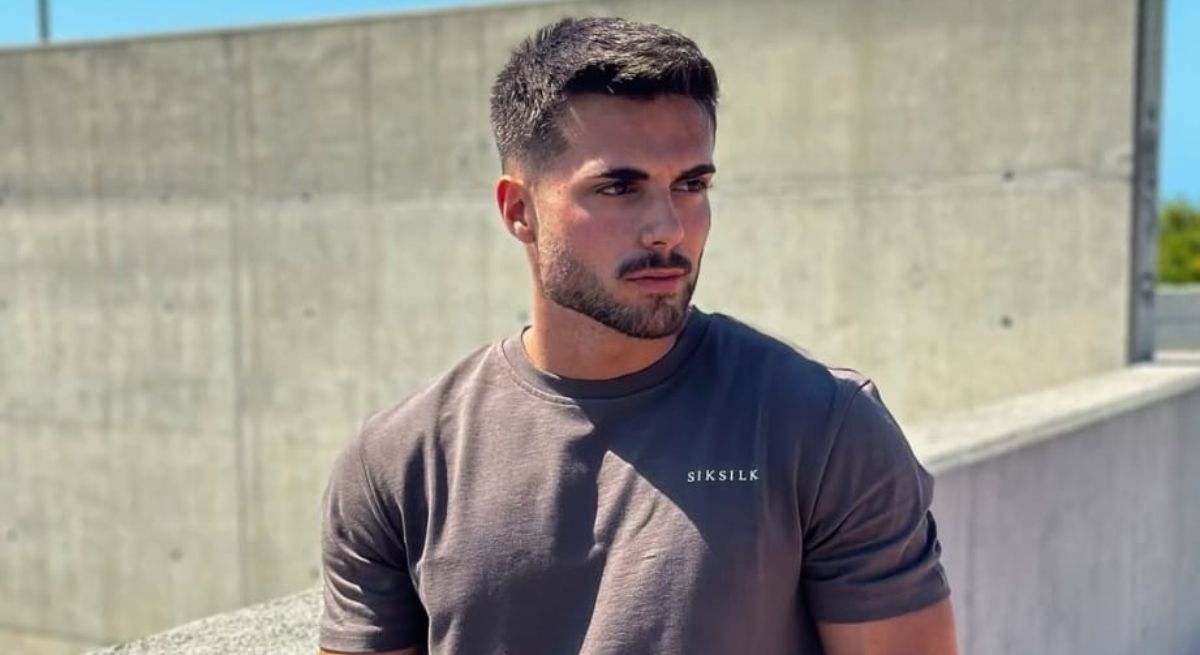 Joel posando con una camiseta de manga corta en un parque