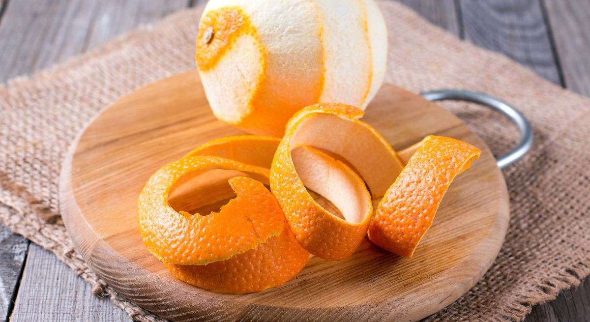 Piel de naranja sobre un plato de madera