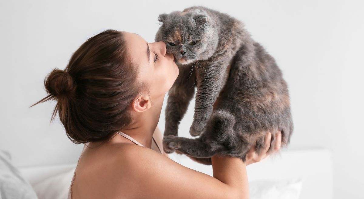 Una mujer besa a su gato 