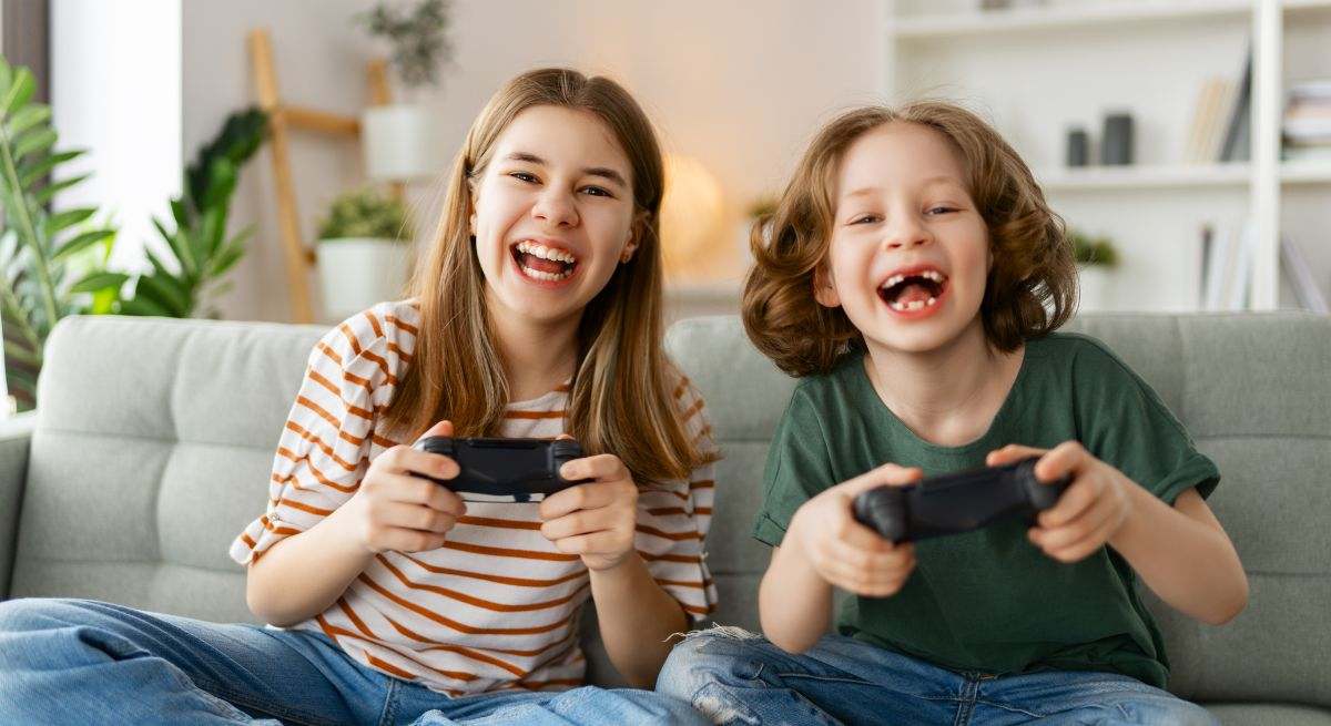 Dos niños jugando a la consola en su hogar