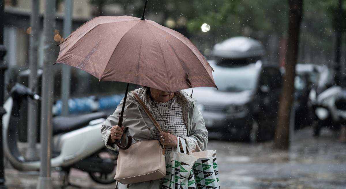 Una mujer usa un paraguas para protegerse de la lluvia.