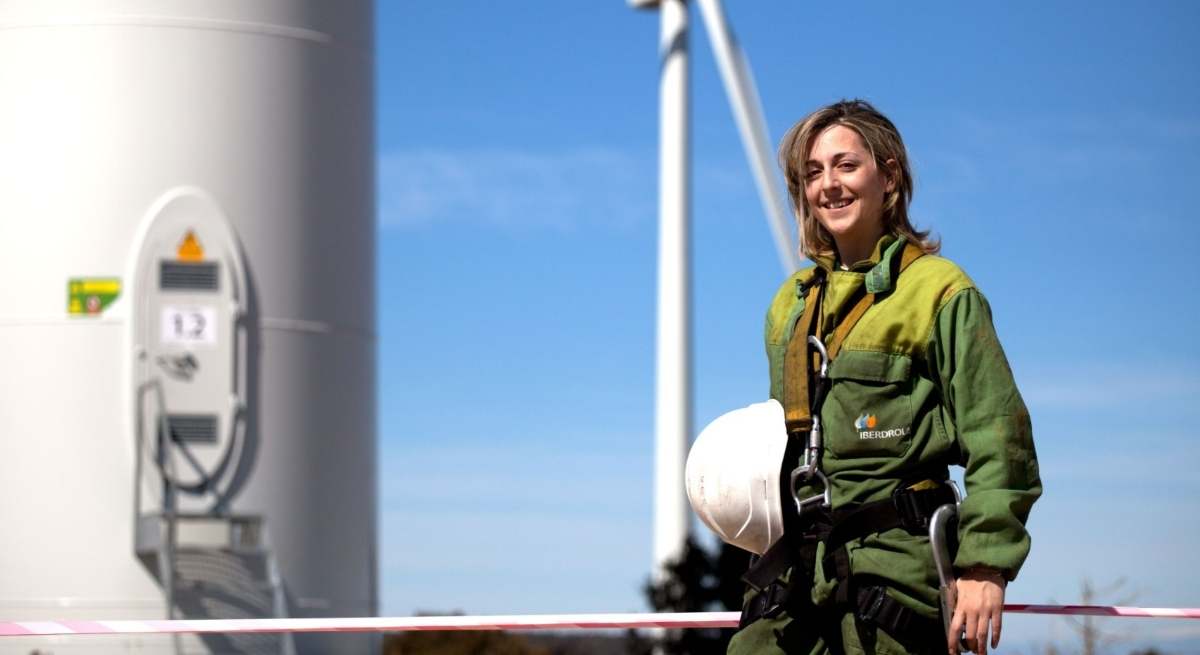 Una mujer ante un molino de Iberdrola / Europa Press
