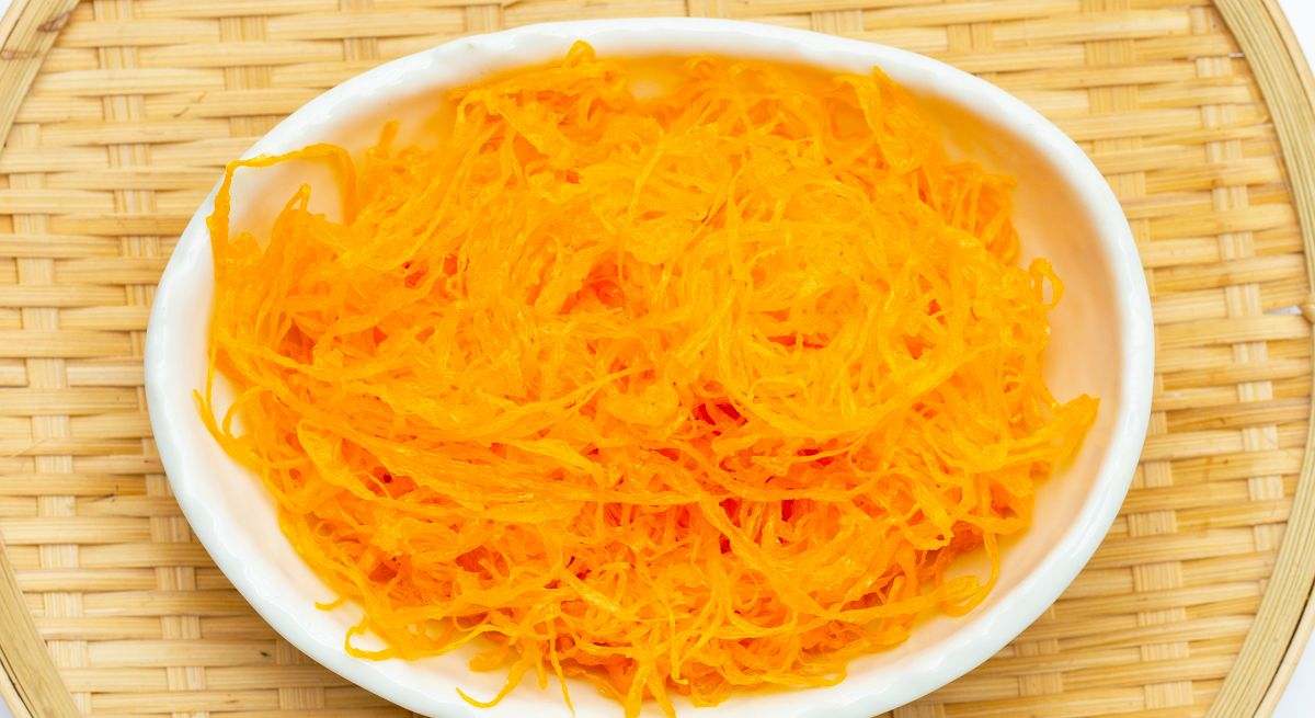 Un plato repleto de hilos de huevo naranjas