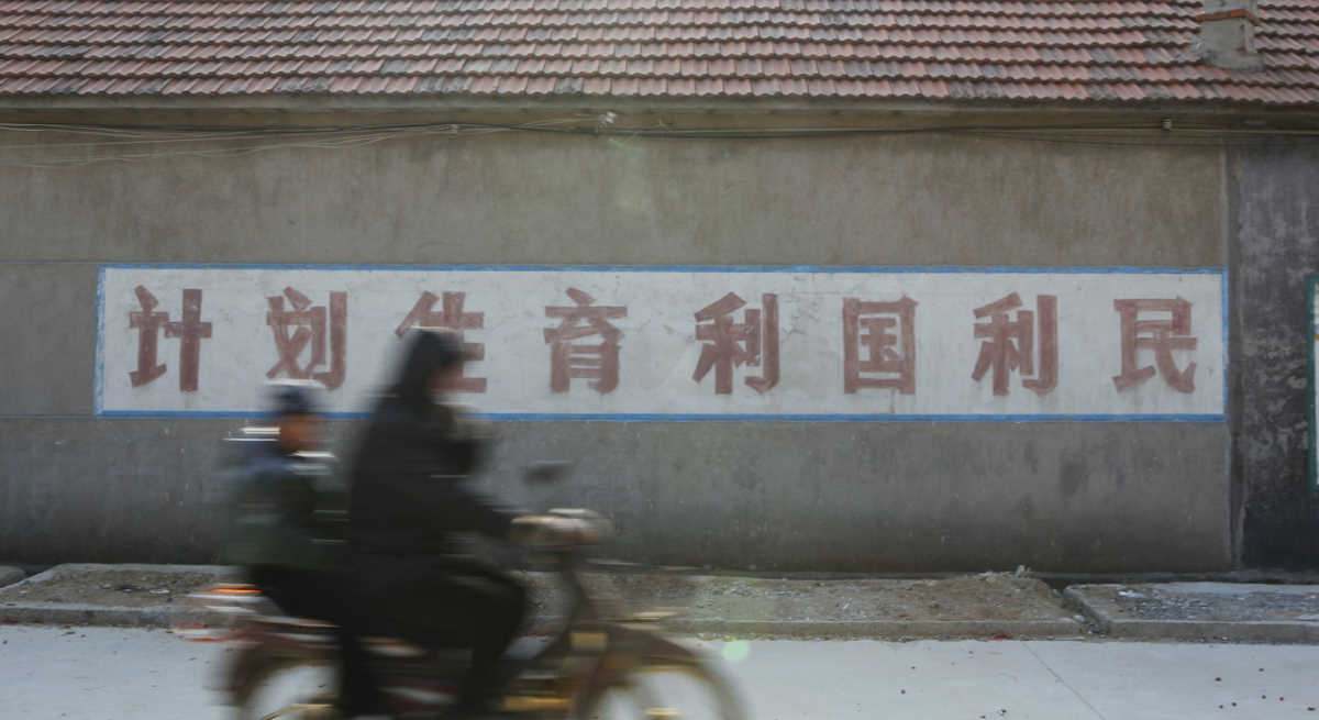 Un motorista delante de un mural de propaganda