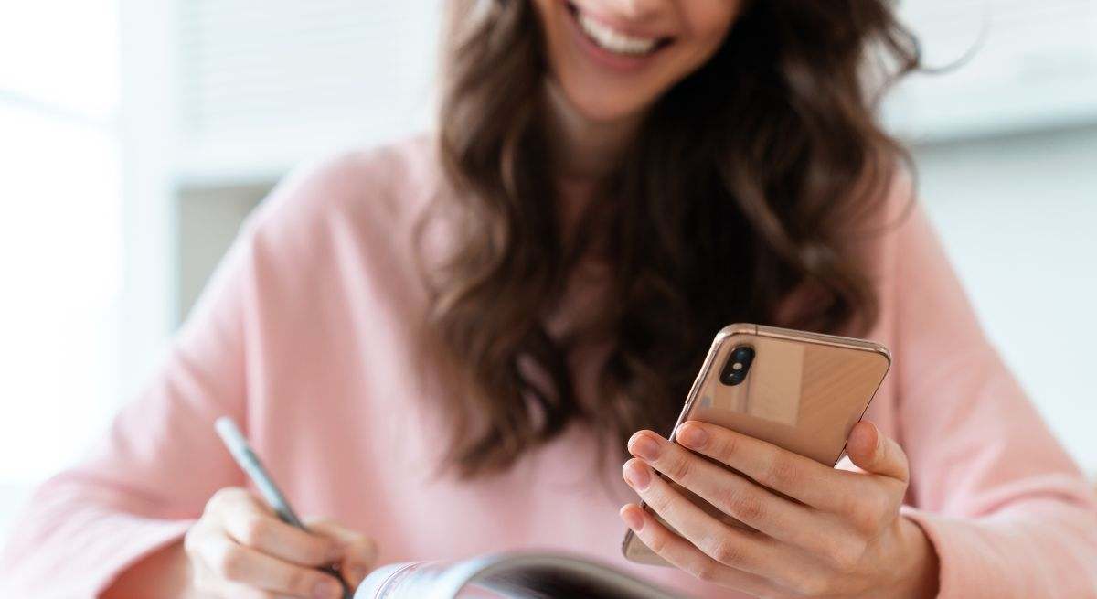 Una mujer sonríe al teléfono móvil 
