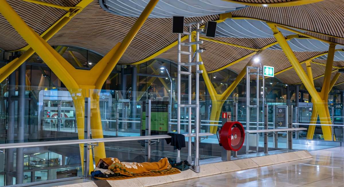 Una persona duerme en el Aeropuerto de Barajas
