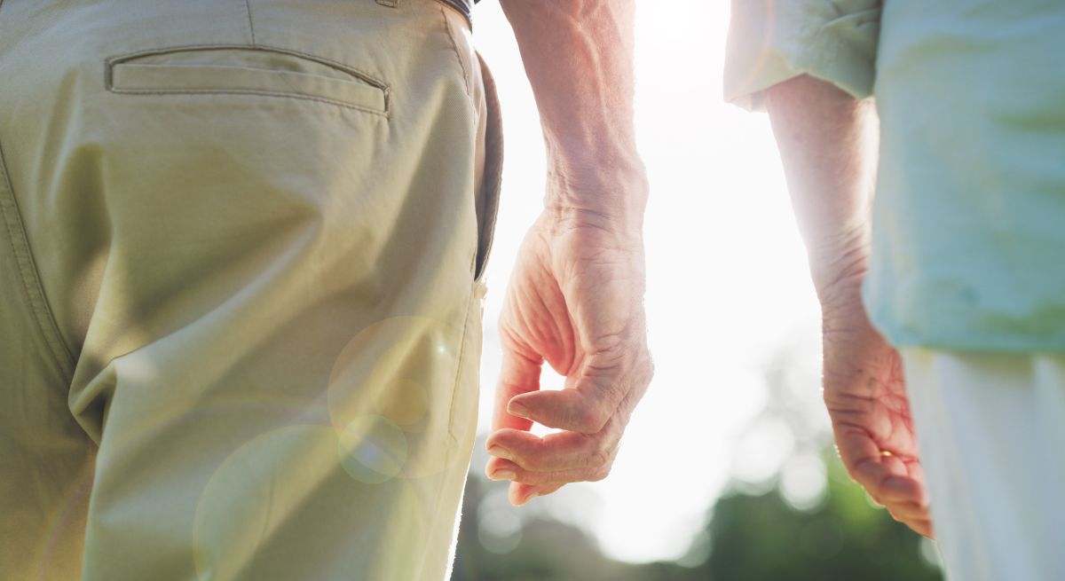 Dos personas de avanzada pasean plácidamente por un parque